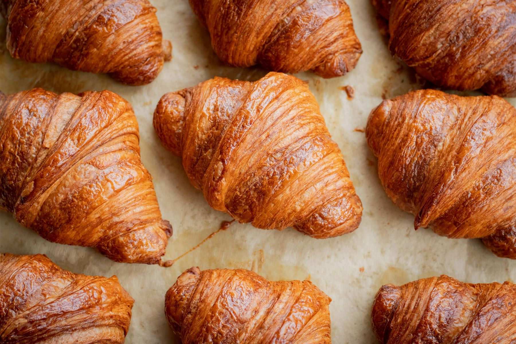 Des croissants au beurre bien dorés, alignés sur une plaque de cuisson.